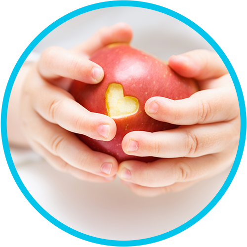 Baby hands holding apple with heart cut out